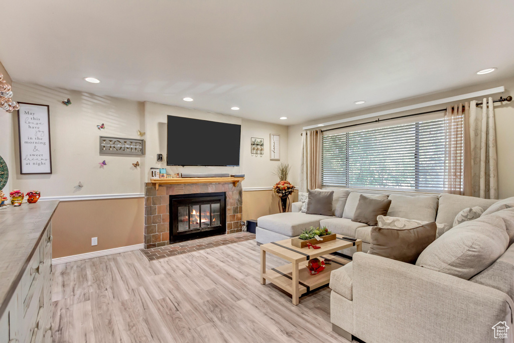 Living room with a fireplace and light wood-type flooring