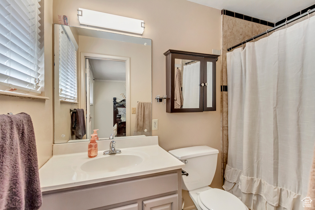 Bathroom featuring vanity, a shower with shower curtain, and toilet