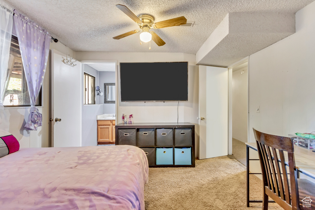 Carpeted bedroom featuring a textured ceiling and ceiling fan