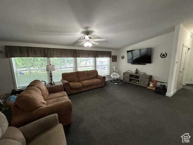 Carpeted living room with vaulted ceiling and ceiling fan