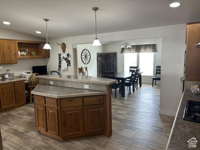 Kitchen with hardwood / wood-style flooring, hanging light fixtures, and a kitchen island