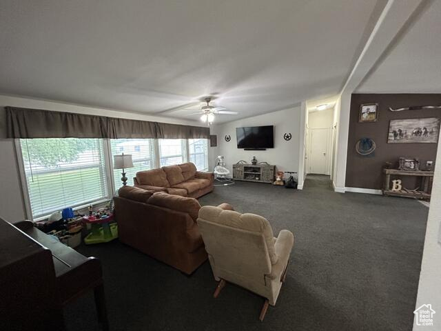 Carpeted living room featuring ceiling fan