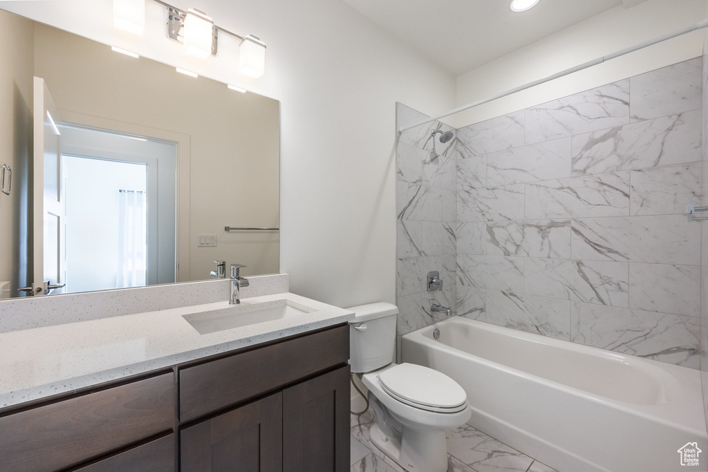 Full bathroom with vanity, toilet, and tiled shower / bath