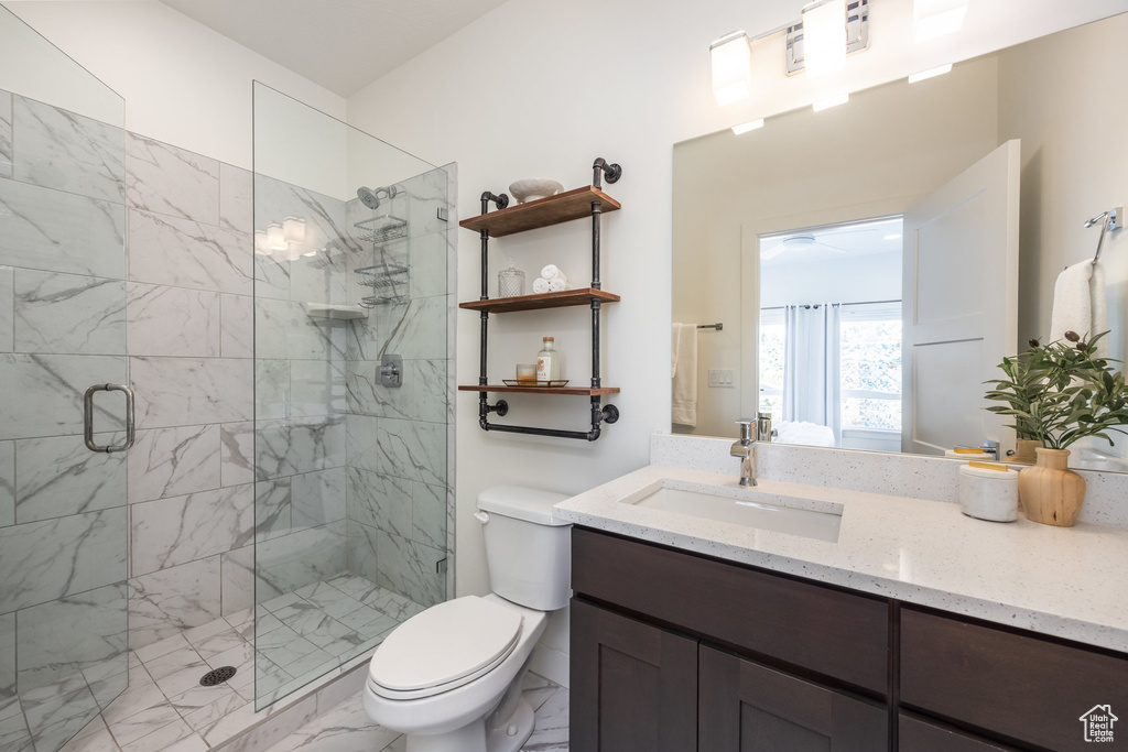 Bathroom featuring vanity, walk in shower, and toilet