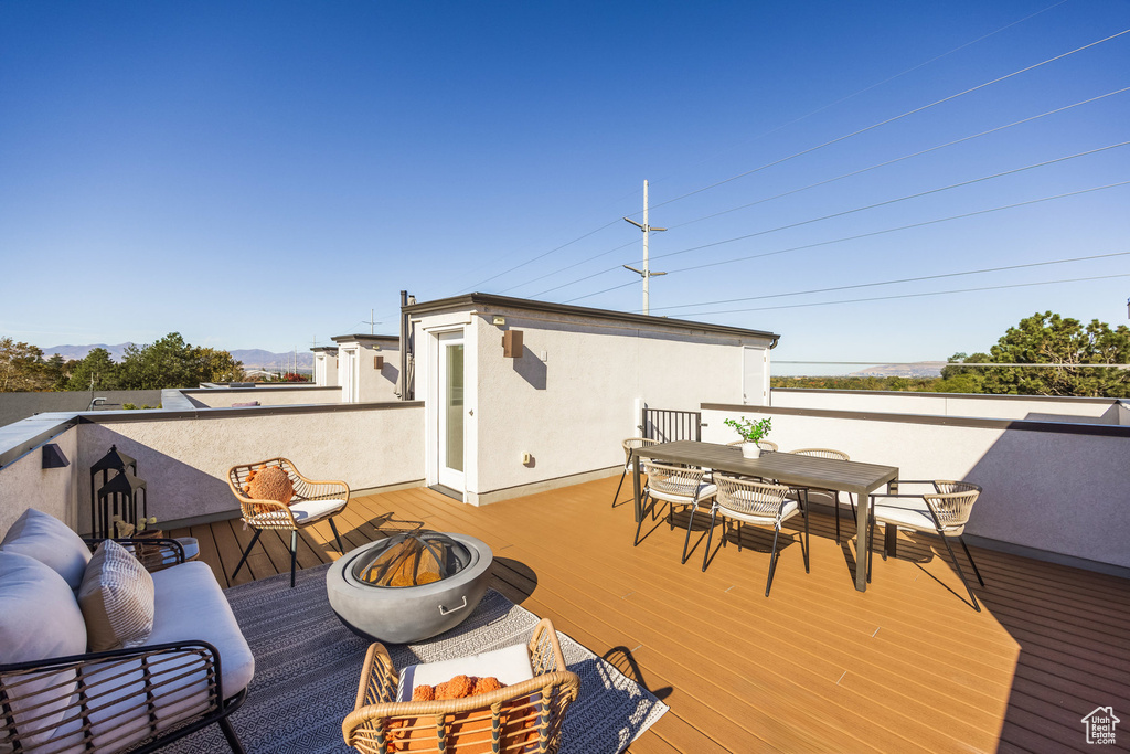 Wooden terrace featuring a fire pit