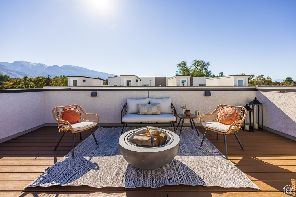 Wooden deck featuring a mountain view and an outdoor fire pit