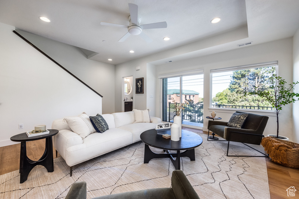 Living room with ceiling fan and light hardwood / wood-style flooring