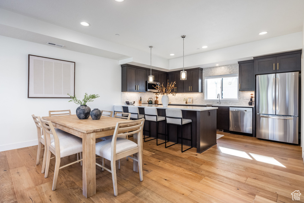 Dining space with sink and light hardwood / wood-style flooring