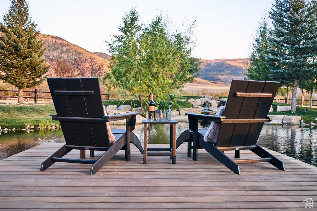 Wooden terrace featuring a water and mountain view