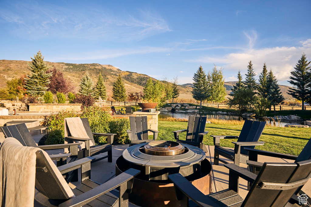 View of patio / terrace featuring an outdoor fire pit and a water and mountain view