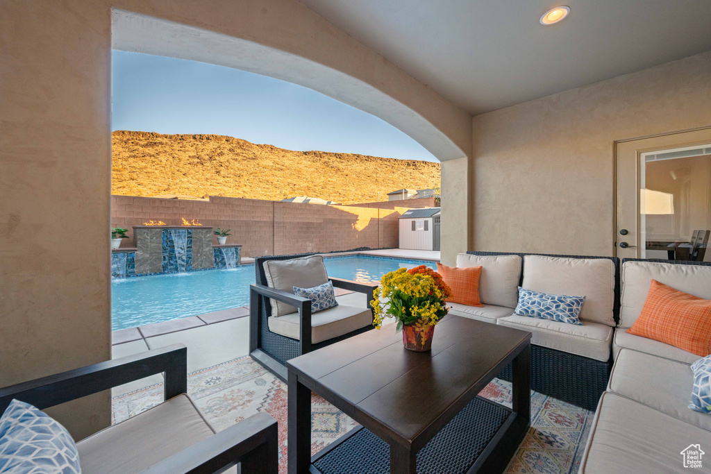 View of patio / terrace with a mountain view, pool water feature, a fenced in pool, and an outdoor living space