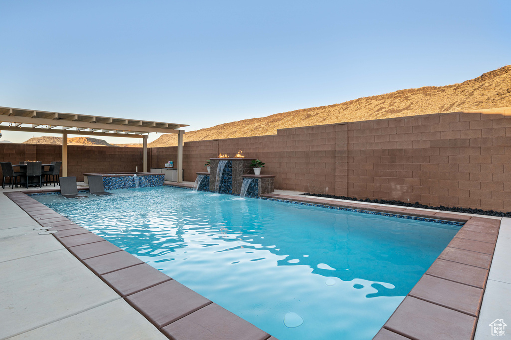 View of swimming pool with a jacuzzi, a patio area, pool water feature, and a pergola