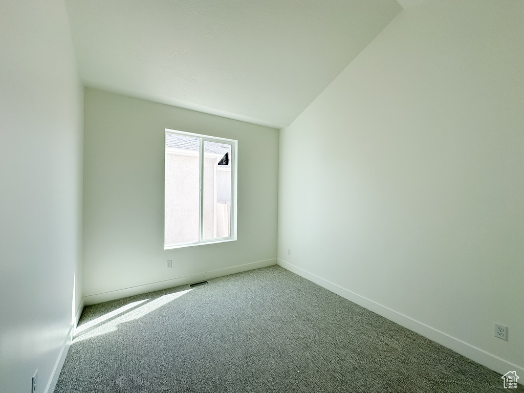 Carpeted spare room with visible vents and baseboards