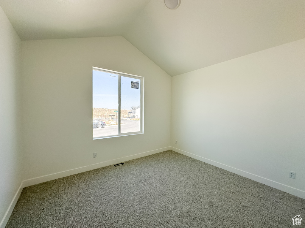 Interior space with visible vents, baseboards, carpet, and lofted ceiling