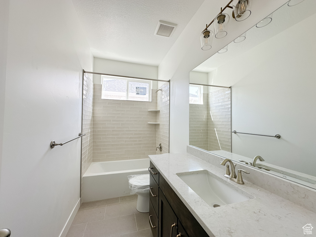 Full bathroom featuring visible vents, toilet, a textured ceiling, vanity, and tile patterned flooring