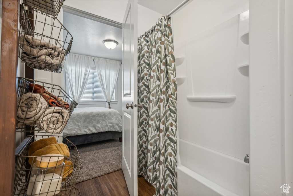 Bathroom featuring hardwood / wood-style floors and shower / bath combo with shower curtain