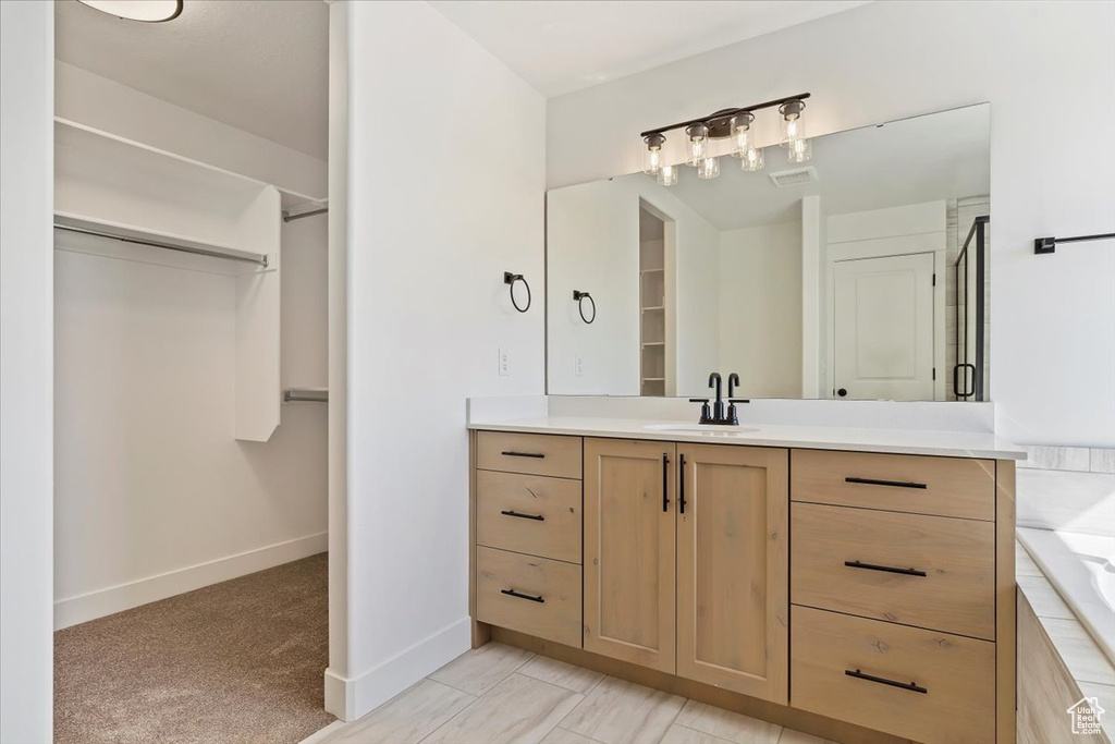 Bathroom featuring vanity, tile patterned flooring, and a bathing tub