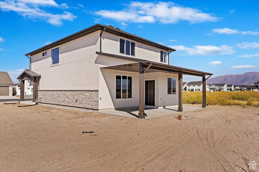 Back of property with a patio and a mountain view