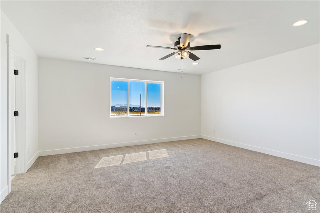 Carpeted empty room featuring ceiling fan