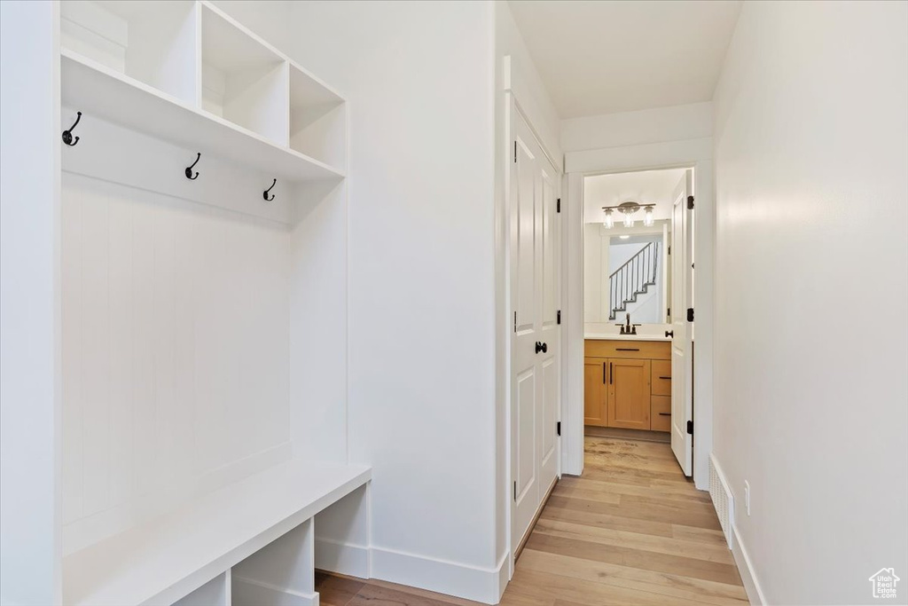 Mudroom with sink and light wood-type flooring