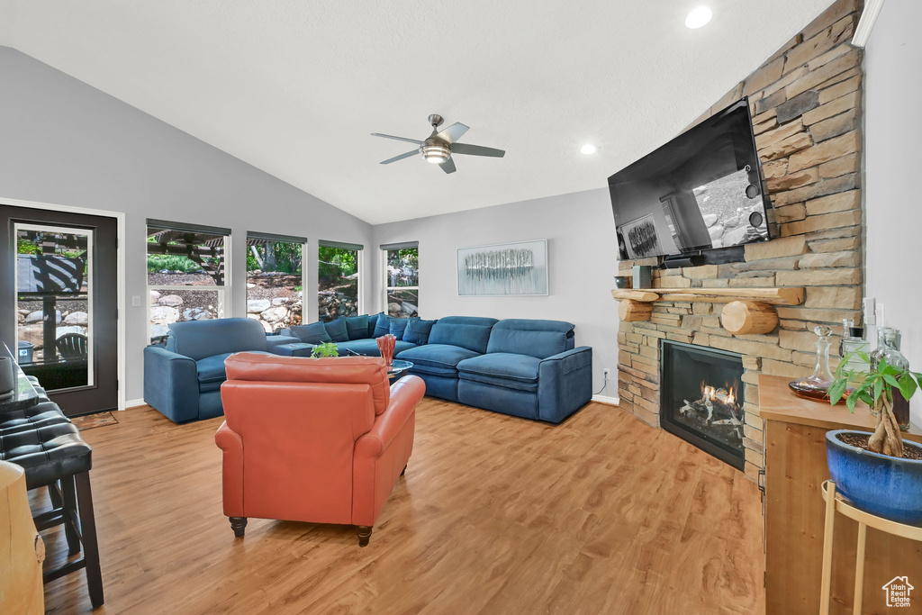 Living room with a fireplace, lofted ceiling, ceiling fan, wood finished floors, and recessed lighting
