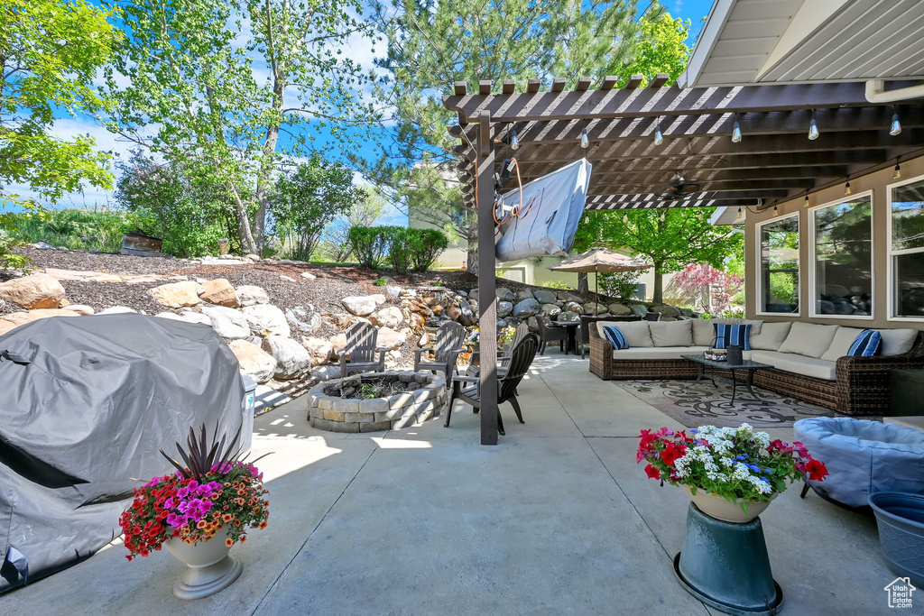 View of patio featuring an outdoor living space with a fire pit, a pergola, and area for grilling