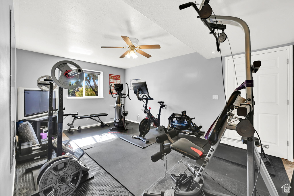 Workout room featuring a ceiling fan and baseboards