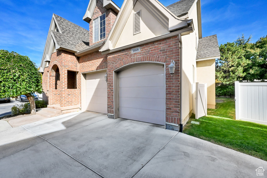 View of front of property featuring a garage and a front lawn