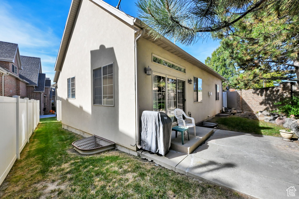 Rear view of property with a yard and a patio