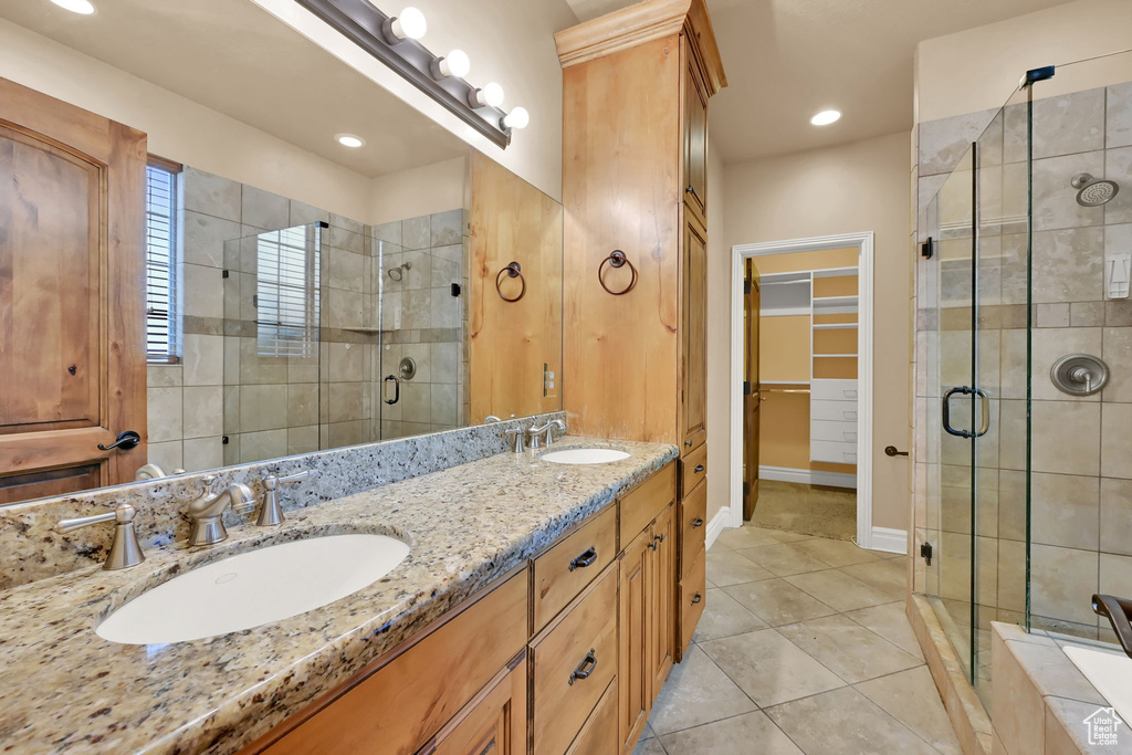 Bathroom with vanity, an enclosed shower, and tile patterned flooring