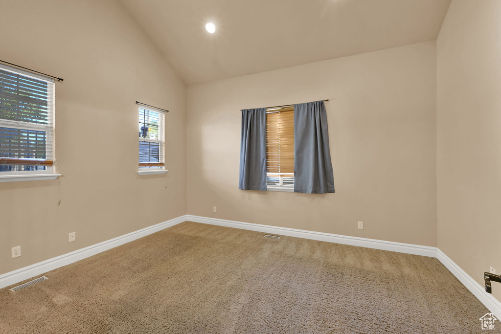 Unfurnished room with high vaulted ceiling and carpet flooring