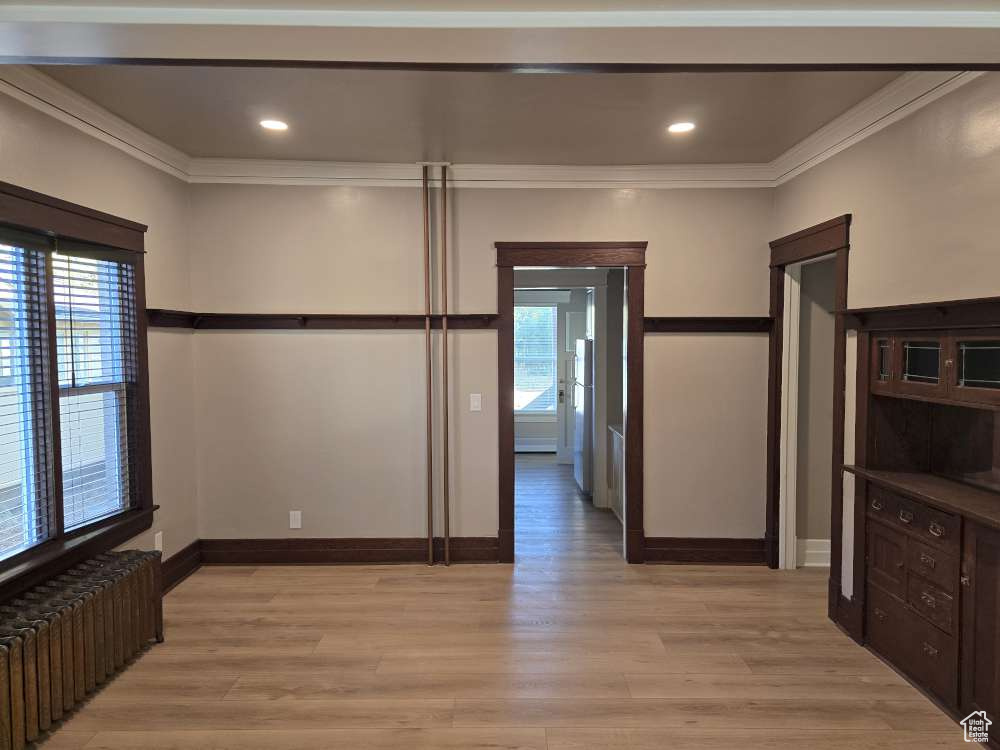 Interior space featuring light hardwood / wood-style floors, crown molding, and radiator heating unit