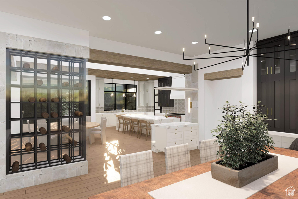 Interior space with light hardwood / wood-style floors, a notable chandelier, and white cabinets