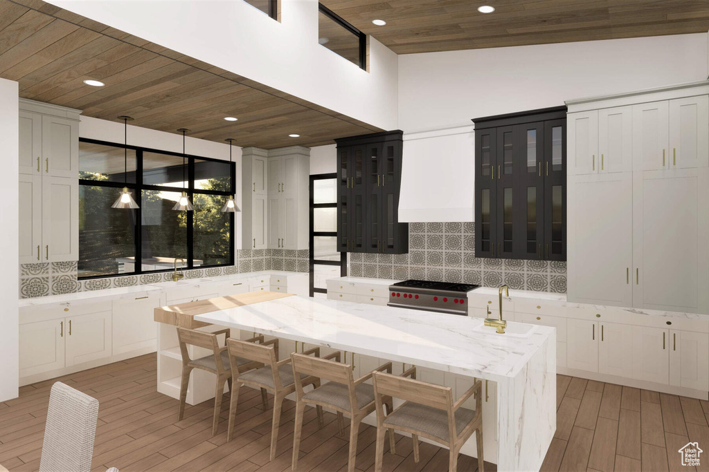 Kitchen featuring a center island, hanging light fixtures, high end stainless steel range, lofted ceiling, and decorative backsplash