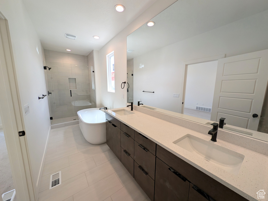 Bathroom featuring double vanity, a sink, a freestanding bath, and a shower stall