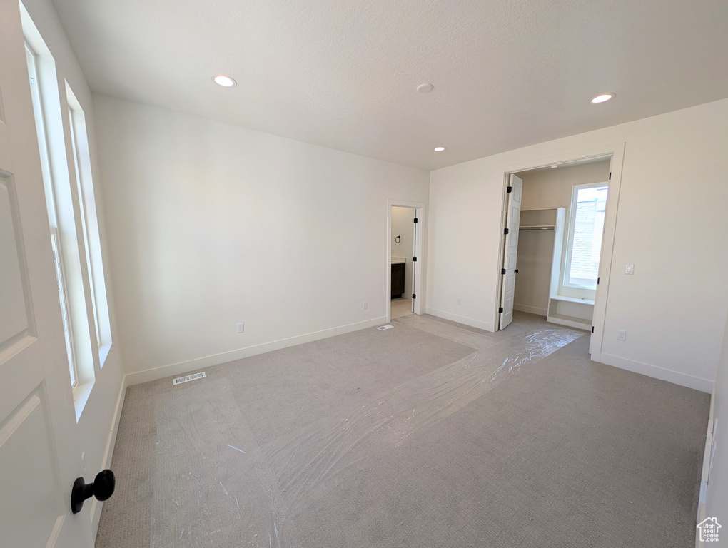 Empty room with recessed lighting, baseboards, visible vents, and light carpet