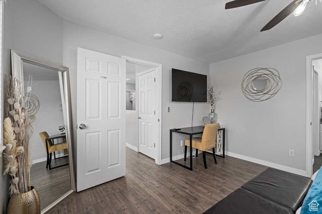 Interior space with ceiling fan and dark hardwood / wood-style flooring