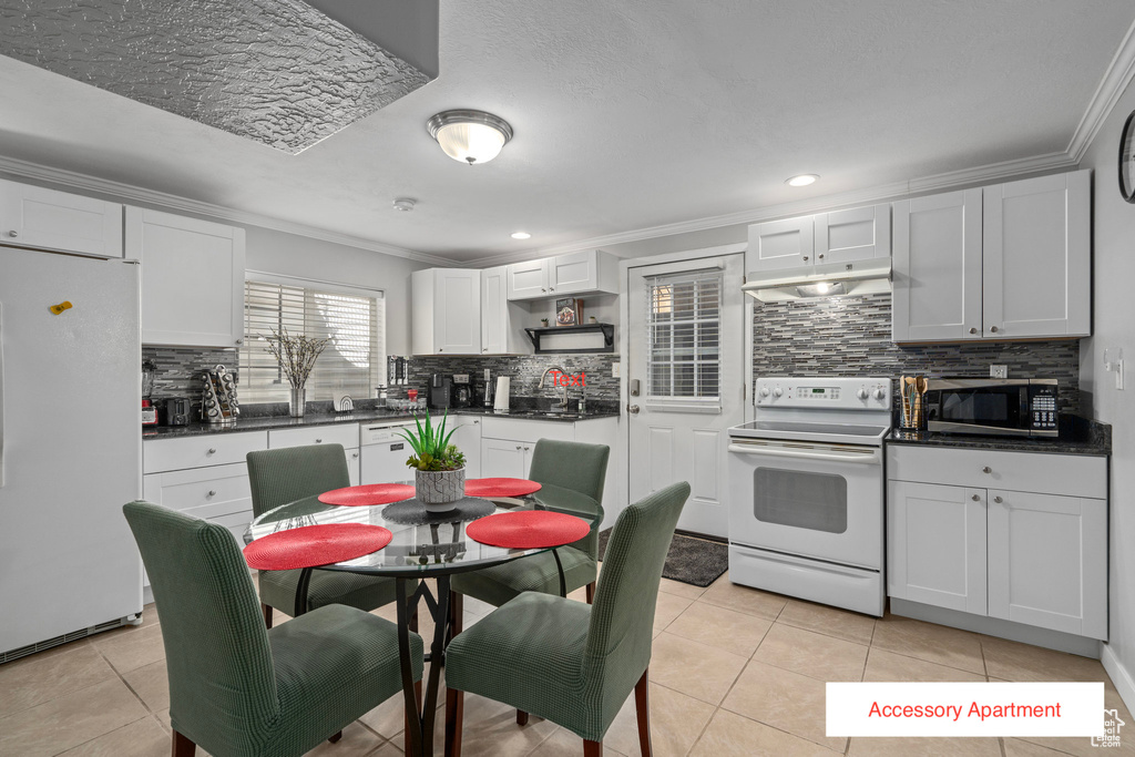 Kitchen with ornamental molding, white cabinetry, tasteful backsplash, and white appliances