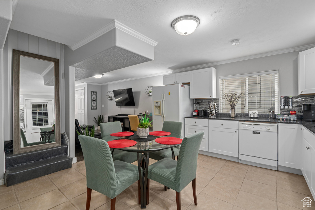 Kitchen featuring crown molding, white cabinetry, white appliances, and tasteful backsplash