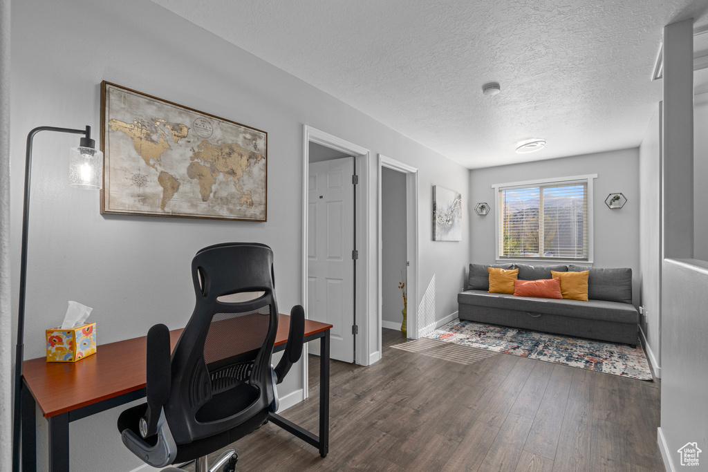 Office area featuring a textured ceiling and dark hardwood / wood-style flooring