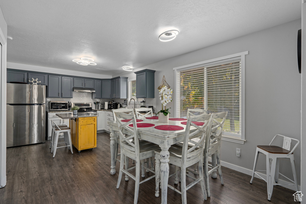 Dining area featuring a textured ceiling and dark hardwood / wood-style flooring