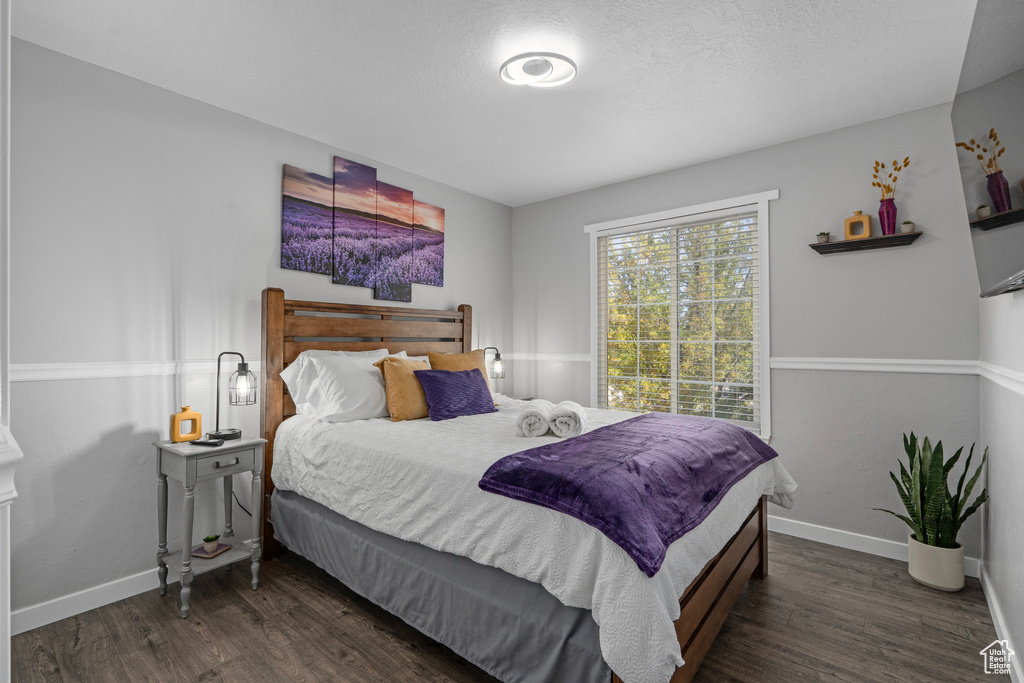 Bedroom featuring a textured ceiling and dark hardwood / wood-style flooring