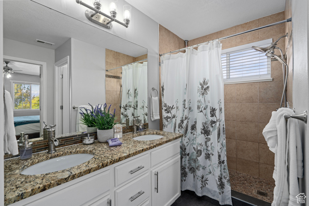 Bathroom featuring vanity, ceiling fan, and a shower with shower curtain