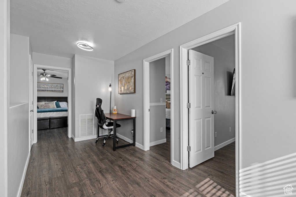 Office area with ceiling fan, a textured ceiling, and dark hardwood / wood-style flooring