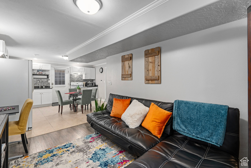 Living room featuring light hardwood / wood-style floors, a textured ceiling, and sink