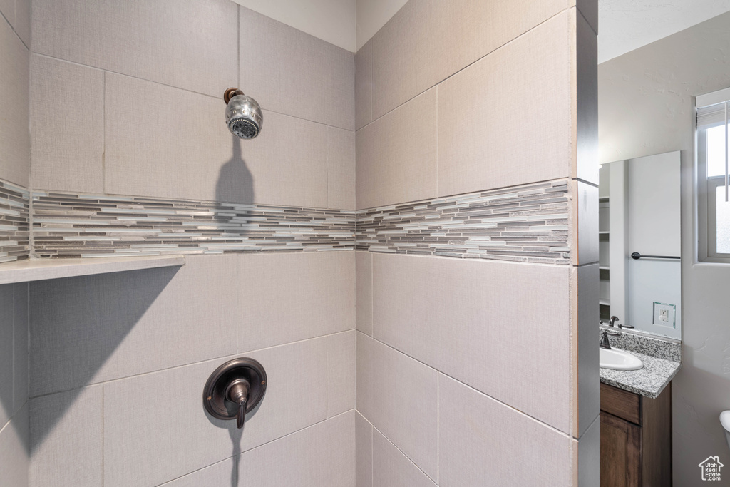 Bathroom featuring vanity, tasteful backsplash, and a shower