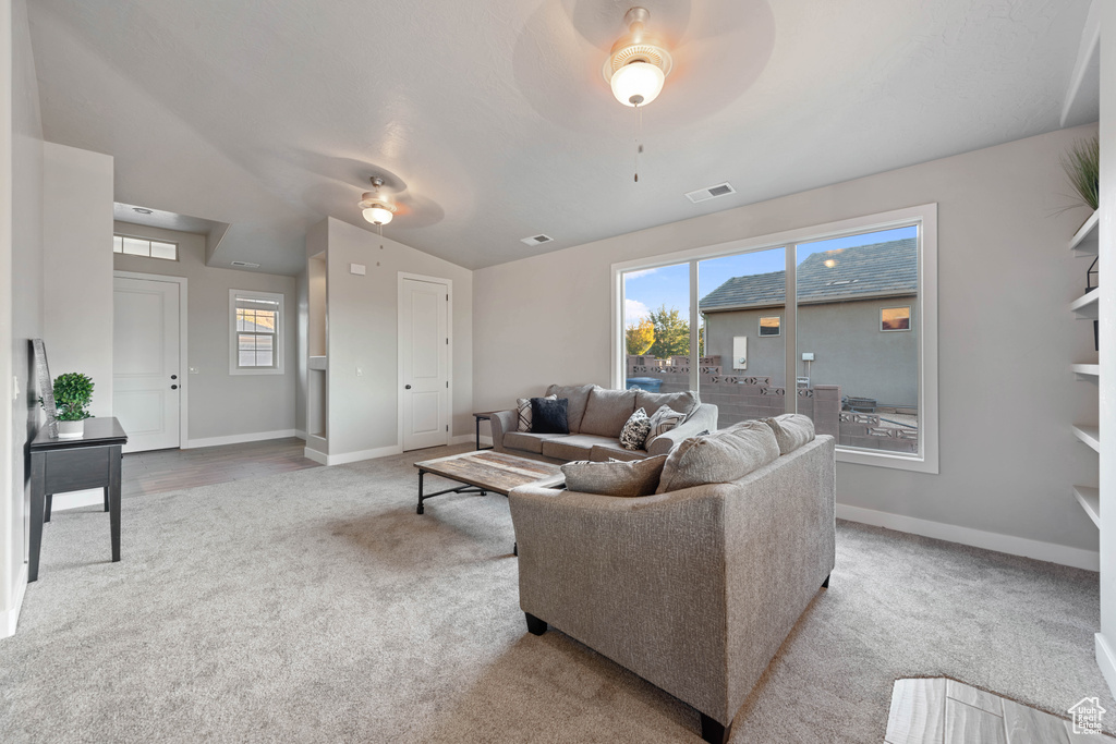 Living room with vaulted ceiling, light carpet, and ceiling fan