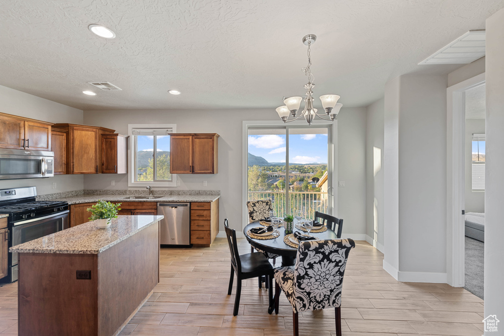 Kitchen featuring sink, appliances with stainless steel finishes, a center island, and a wealth of natural light