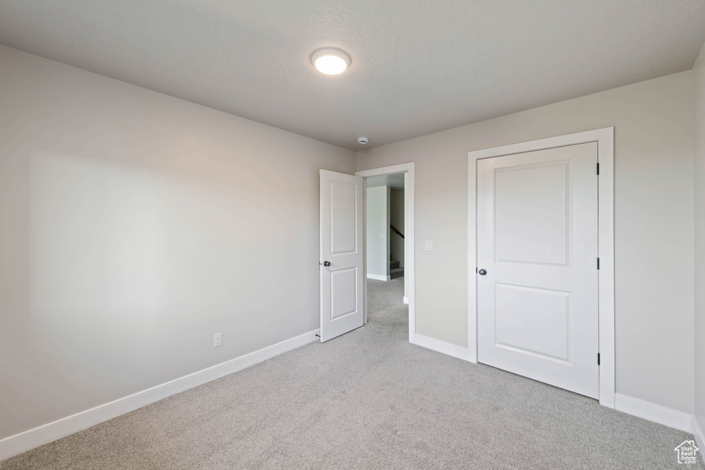 Unfurnished bedroom with light colored carpet