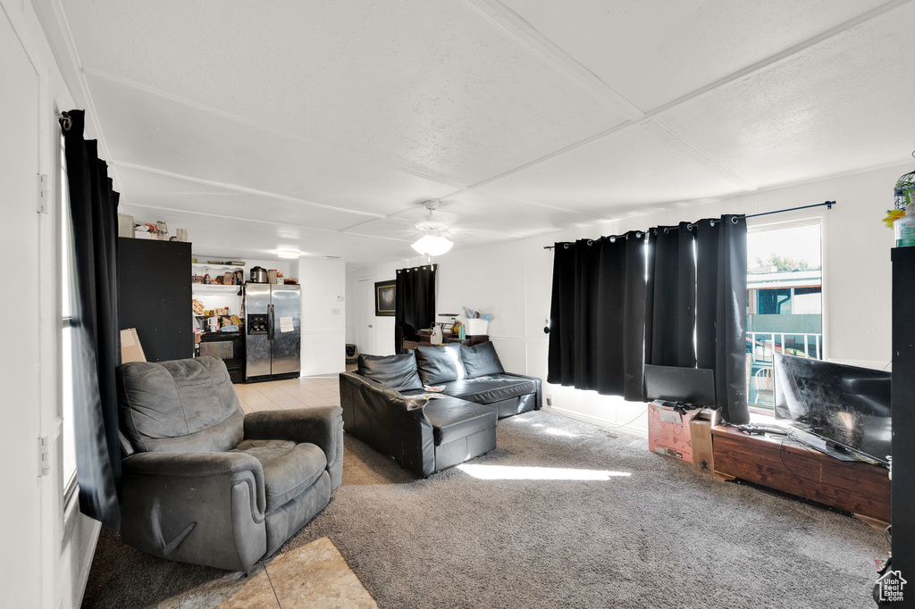 Living room featuring light carpet, a textured ceiling, and ceiling fan